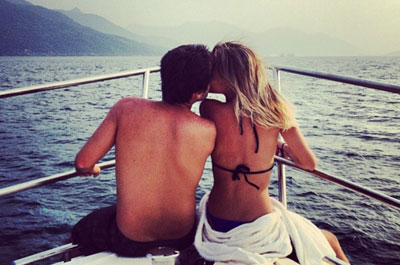 Couple enjoying on front deck of private yacht in Dubai cruising across the blue sea