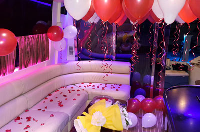 Party Yacht in Dubai beautifully decorated for birthday with red and white balloons, rose petals and cake in lounge